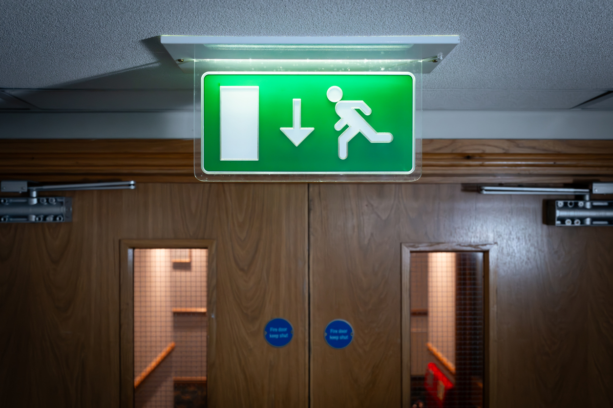 close up of the top half of a fire door and emergency exit sign